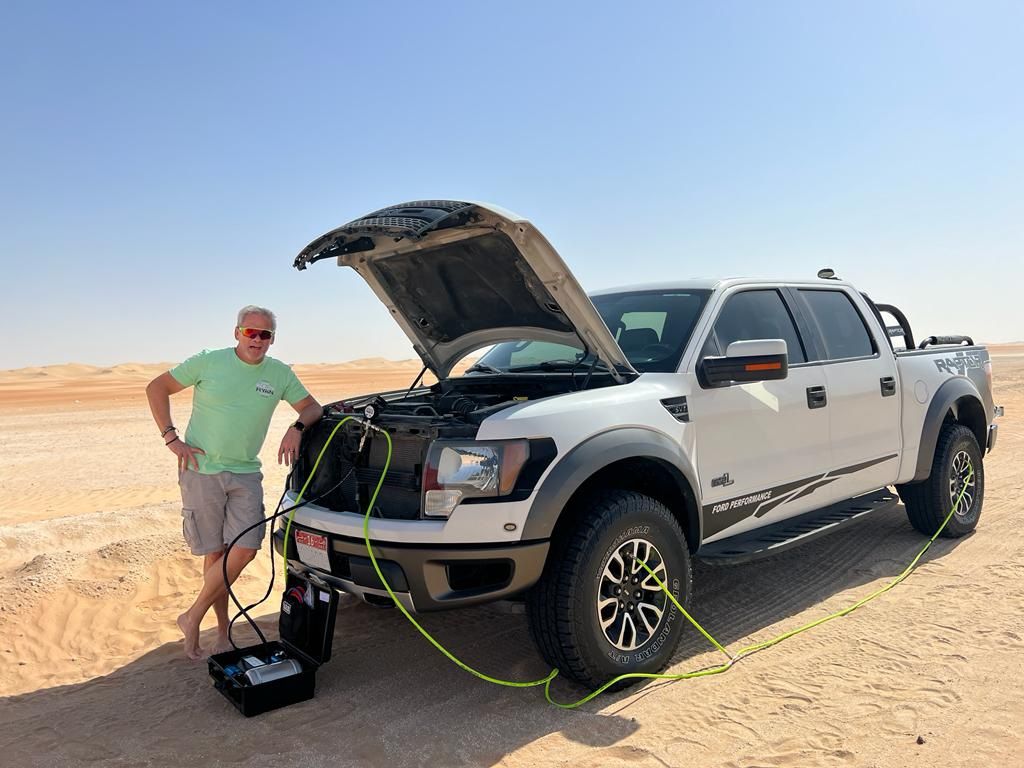 The Greenzilla 4in1 in use in the desert: green hoses running from the gauge hub to the wheels of a 4x4.