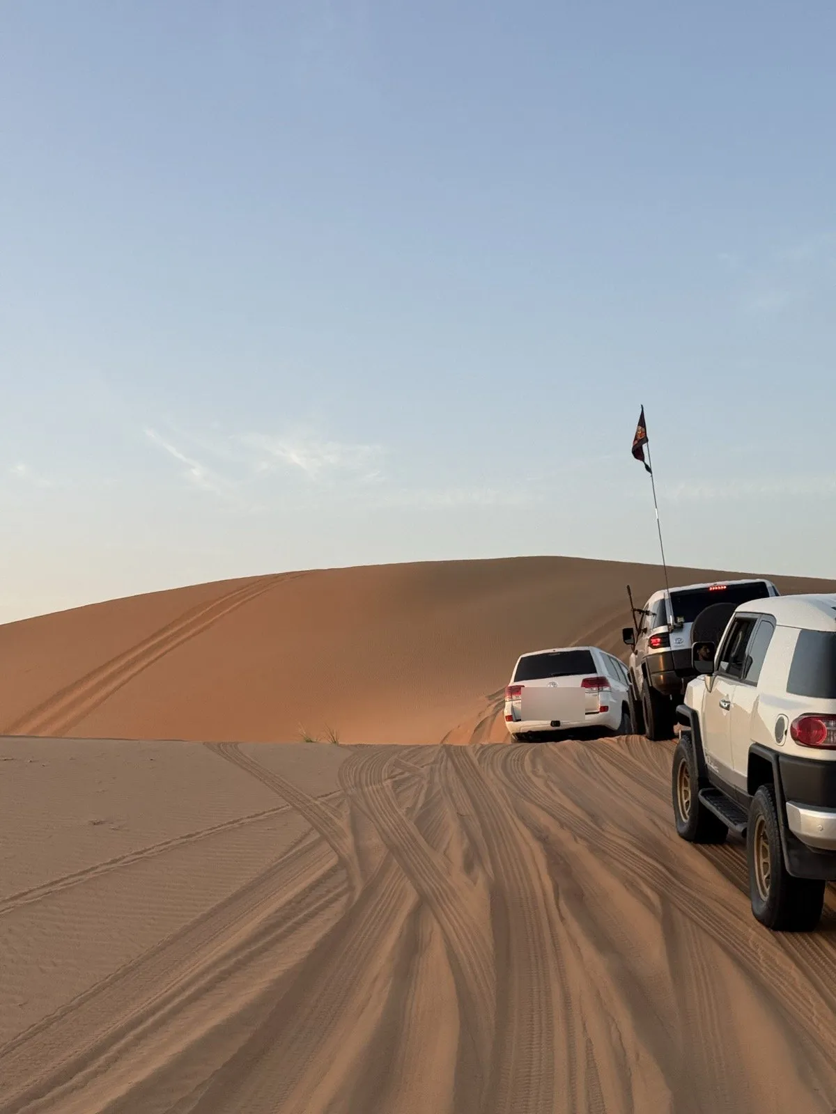 A convoy paused on a large dune ridge at Liwa, on the northern rim of the Rub' al Khali, at dusk