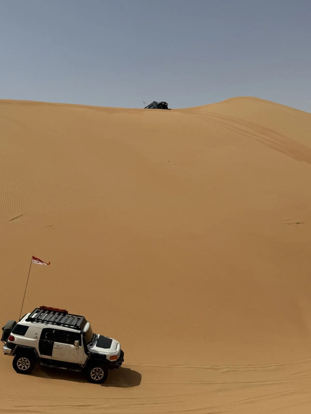 A flagged FJ Cruiser below the long climb at Nagrah Hill, another 4x4 already on the crest