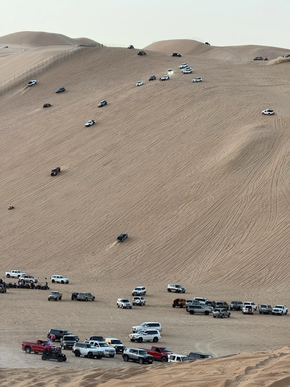Dozens of 4x4s at the base of Tal Moreeb, with vehicles working the face above